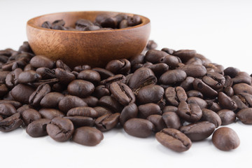 Stack of coffee beans with wooden bowl