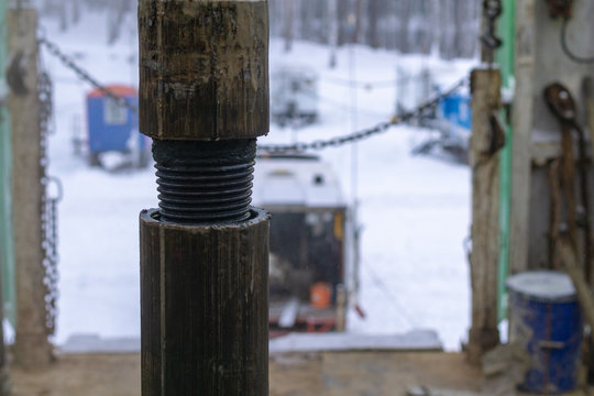 Offshore Oil Rig Worker Prepare Tool And Equipment For Perforation Oil And Gas Well At Wellhead Platform. Making Up A Drill Pipe Connection. A View For Drill Pipe Connection From Between The Stands.