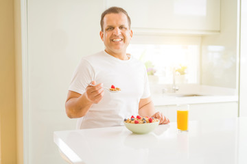 Senior man eating cereals for breakfast in the morning