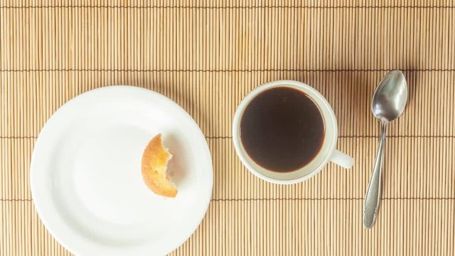 Stop motion, animation. A cake on a plate and a cup of black natural coffee