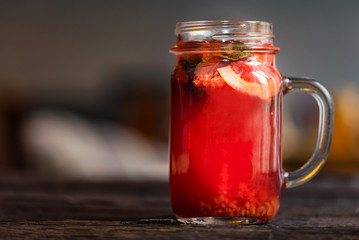 Close up glass jar with delicious healthy raspberry tea drink