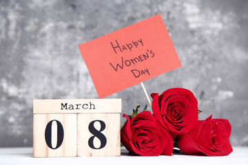 Wooden calendar with red roses and text Happy Women's Day