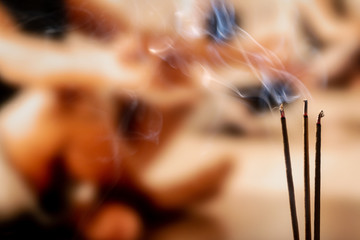 Burning Incense Sticks with smoke, joss sticks burning at a vintage Buddhist temple