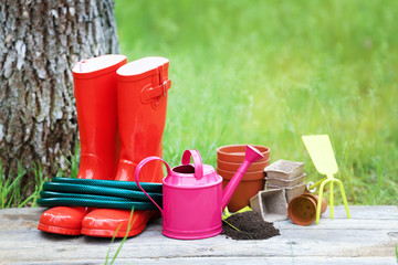 Garden tools with pots on wooden board