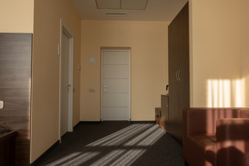 beige hotel room interior with wardrobe, armchair and doors