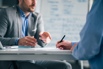 Business people negotiating, signing a contract, close-up.