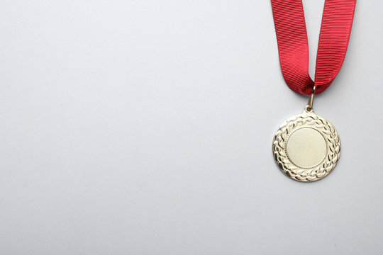 Gold medal with space for design on light background, top view. Victory concept