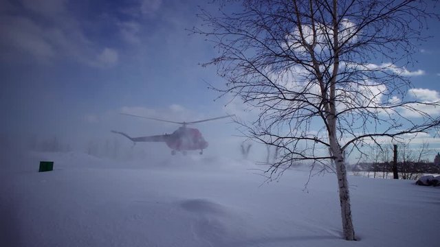 Landing civil helicopter MI-2 on the snow-covered helipad clear day in the park. The sound of the engine and propellers.