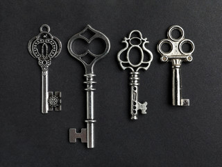 Flat lay composition with silver vintage ornate keys on black background