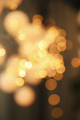 Obraz premium Blurred view of gold lights on dark background. Bokeh effect