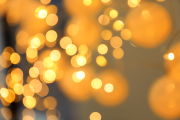 Blurred view of gold lights on dark background. Bokeh effect
