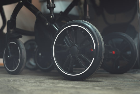 Modern baby carriage wheels close up background.
