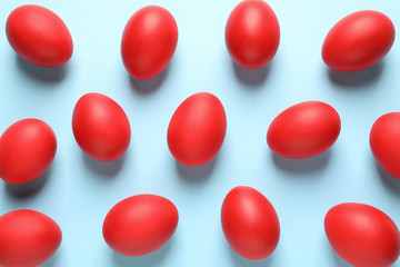 Flat lay composition of red dyed Easter eggs on color background