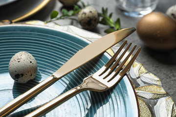 Festive Easter table setting with eggs on color background, closeup