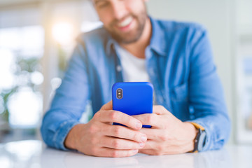 Close up of man hands using smartphone and smiling