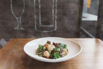 Smoked Galician Octopus with Burrata Cheese, radish, green oak and tomato.