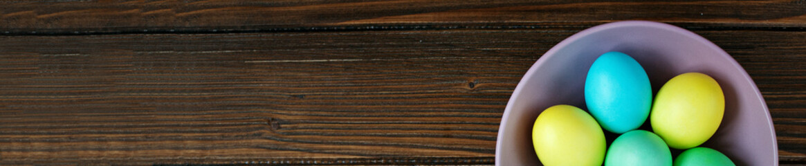 Eggs lie in purple bowl. Top view. Concept Happy Easter.