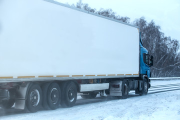 Obraz na płótnie Canvas Truck moves on a country highway in winter