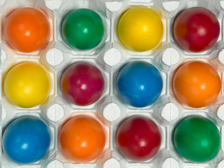 Many multicolored Easter eggs in white egg tray Festive tradition Close up Top view 