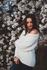 Belle jeune femme au milieu des amandiers en fleurs