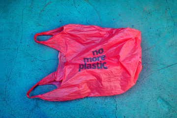 No plastic. Environmental awareness. Red plastic garbage bag with motto.