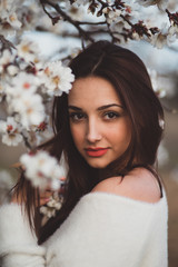 Belle jeune femme au milieu des amandiers en fleurs