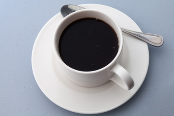 Cup of black coffee top view on blue background