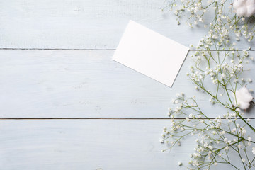 Blank card for invitation or congratulation, little gift box, bunch of gypsophila flowers on light...