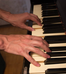 Fototapeta premium Close up of young boy hands, playing piano. vintage piano