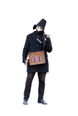 a street musician with a hurdy-gurdy in the mask dressed in black clothes with black hat isolated on white background waving