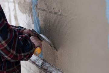 man with a spatula skimming wall