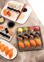 close up of sashimi sushi set with chopsticks and soy - sushi roll with salmon and sushi roll with smoked eel