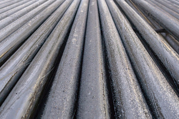 Offshore Industry oil and gas production petroleum pipeline. Downhole drilling rig. Laying the pipe on the deck. View of the shell of drill pipes laid in courtyard of the oil and gas warehouse.