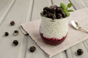 Fototapeta na wymiar Pudding with chia and black currant on the grey wooden background