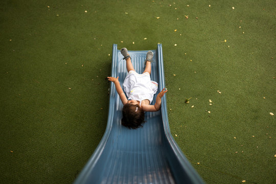 Ni&ntilde;a jugando en un tobogan de un parque