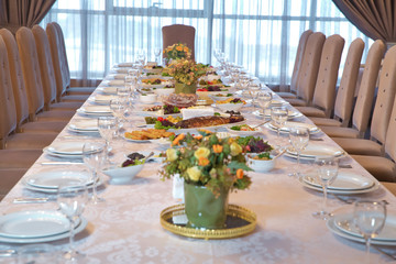Table with empty plates and glasses in the restaurant . Table Setting Food Celebration Party Concept. Served table at summer terrace cafe . Restourant's table prepared for celebrating event.