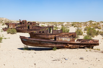Fototapeta na wymiar Rustic boats on a ship graveyards on a desert around Moynaq, Muynak or Moynoq - Aral sea or Aral lake - Uzbekistan in Central Asia
