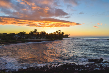 Sunset over ocean and palm trees on the island of Kauai, Hawaii