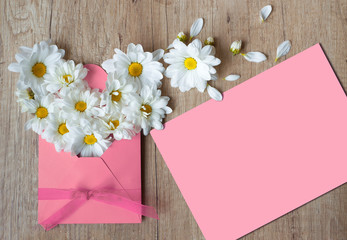 Beautiful Spring flowers. Pink Letter mockup. Chamomile in envelope on a wood background. Free space. Happy Easter. Greeting card. March 8th, mother's day, International Women Day. I love You Mom. Top