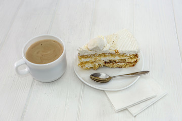 piece of tasty cake  with cup of coffee in white