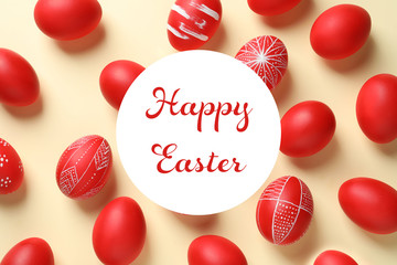 Flat lay composition of red painted eggs and text Happy Easter on color background