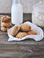 Oat cookies with ingredients on wooden background.