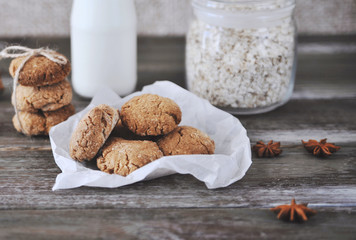 Oat cookies with ingredients on wooden background.