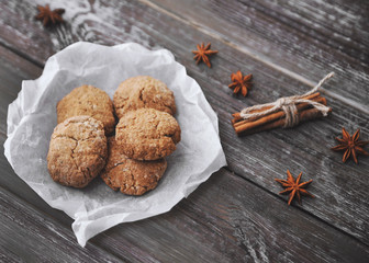 Oat cookies with ingredients on wooden background.