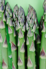 Close up of fresh asparagus spears on a green background
