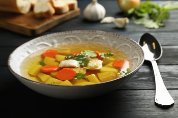 Dish with fresh homemade chicken soup on wooden table