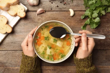 Foto op Plexiglas Woman eating fresh homemade chicken soup at table, top view © New Africa