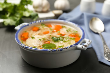 Dish with fresh homemade chicken soup on table