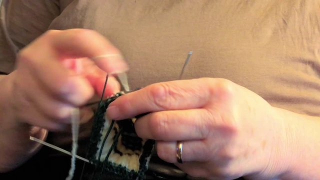 Two hand knitting some yarns and threads to make a handmade item