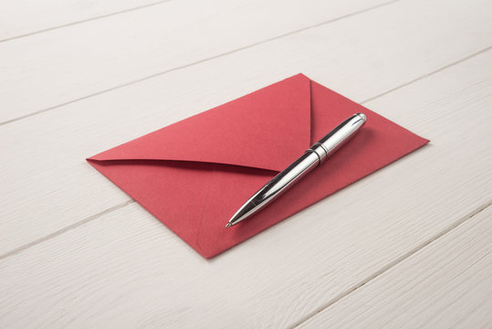 Red envelope and pen on a white background   	 